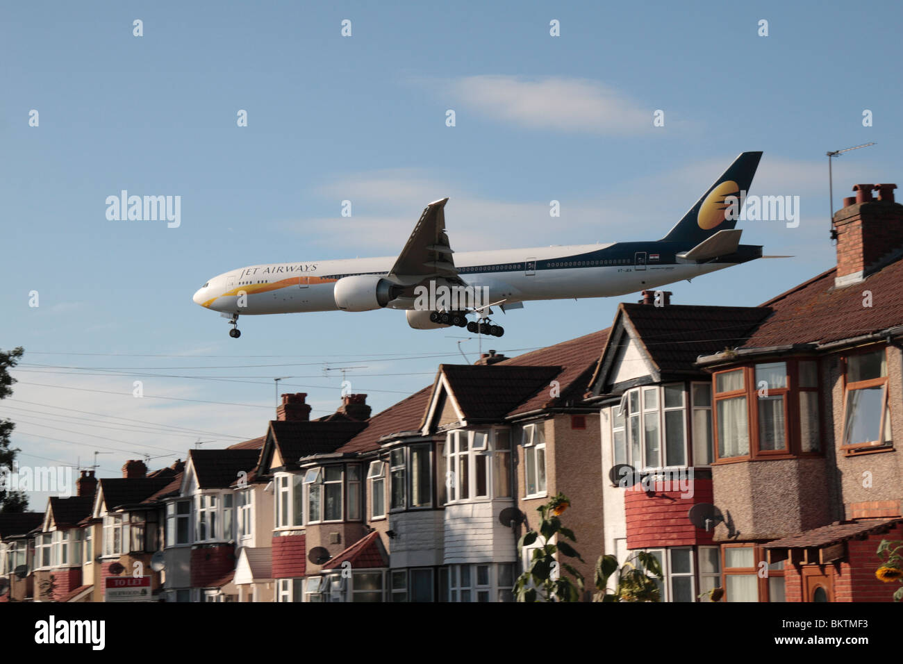 Ein Jet Airways Boeing 777-35R/ER landet auf dem Flughafen Heathrow, London, UK. Ansicht von Myrtle Avenue, Hounslow. (VT-JEA) Stockfoto