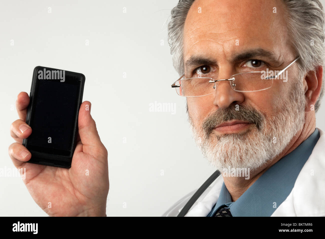 Porträt eines Arztes Brillen-und einen weißen Laborkittel. Er ist ein Handy hochhalten und in die Kamera schaut. Stockfoto