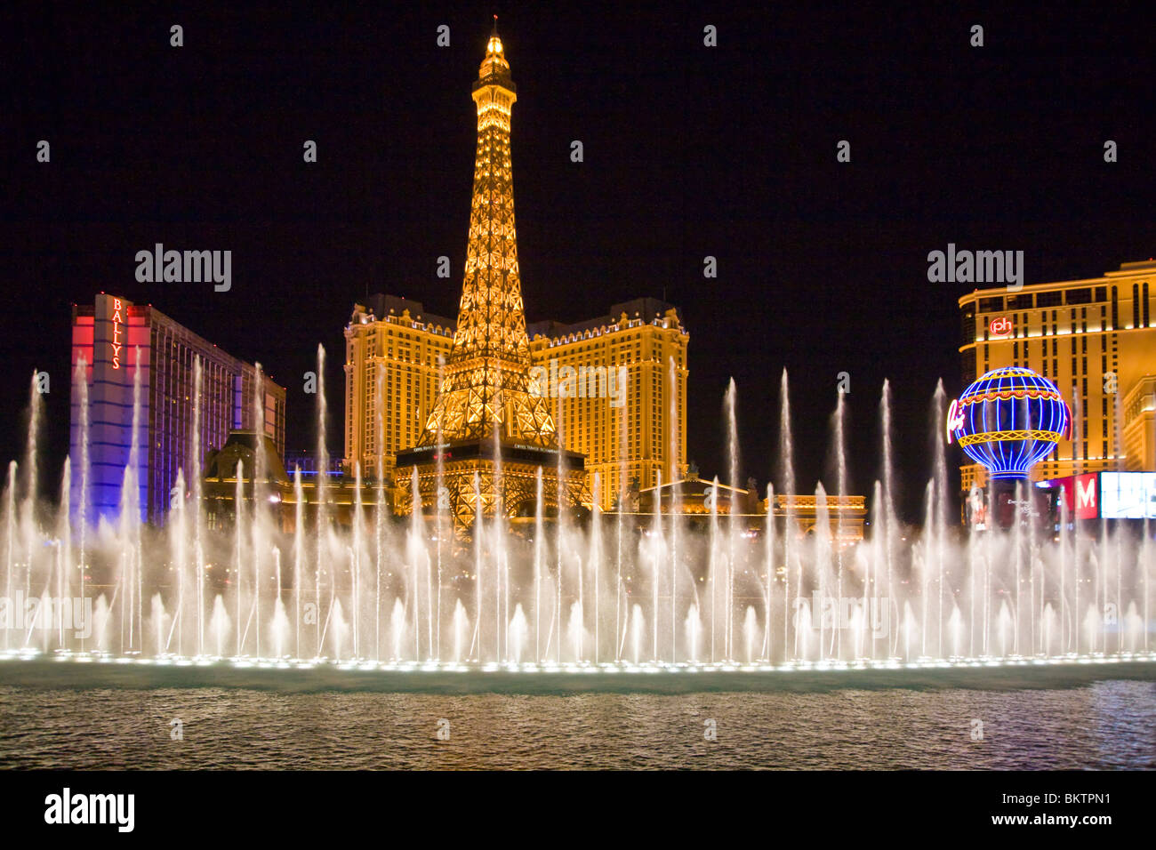Am Abend zeigen Springbrunnen des Bellagio mit Blick auf das PARIS HOTEL AND CASINO - LAS VEGAS, NEVADA Stockfoto