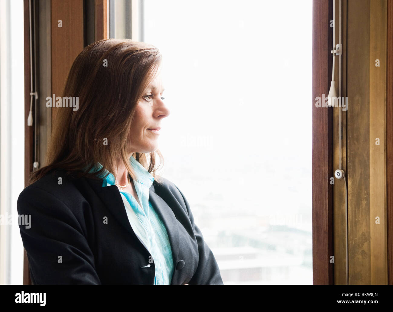 Geschäftsfrau mit Blick durch das Fenster Stockfoto