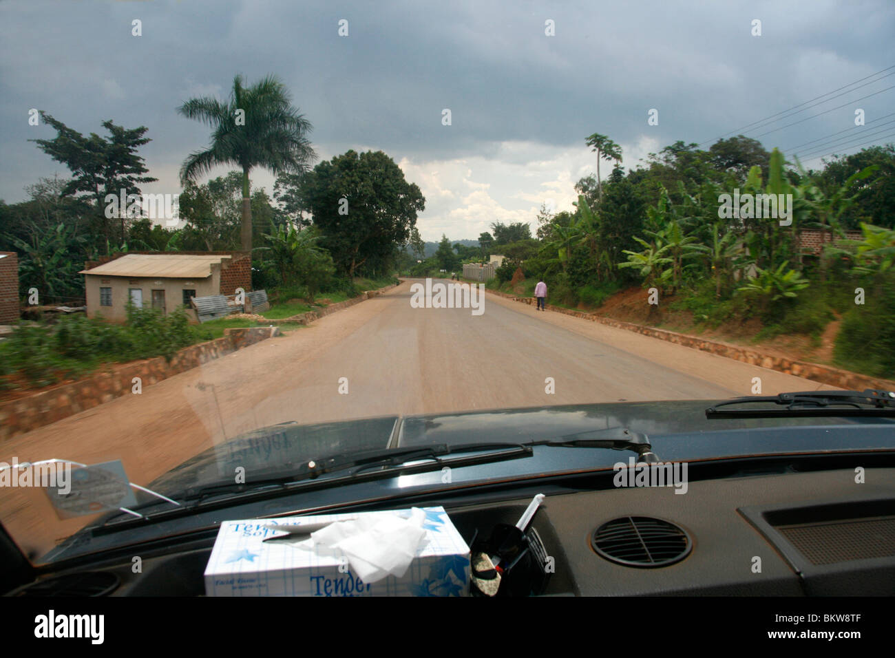 Blick aus der Windschutzscheibe eines Autos eine ugandische Landstraße unterwegs Stockfoto