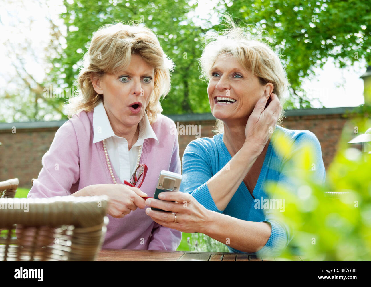 Zwei glückliche Freundinnen Tisch sitzen Stockfoto