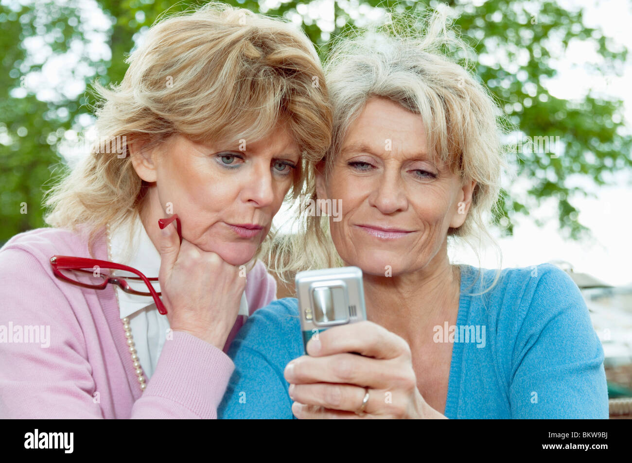 Zwei Erwachsene und ein Handy Stockfoto