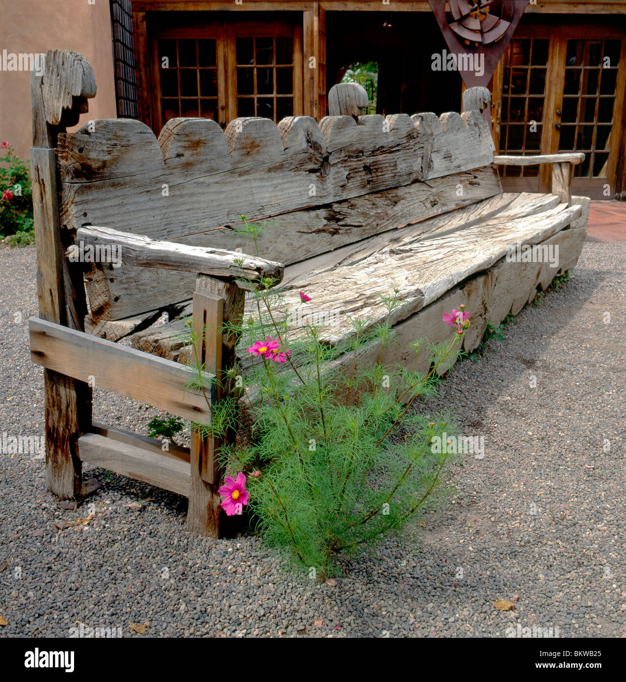 Alte Holzbank und Blumen in einem Garten entlang der Canyon Road, Ort von Galerien & Geschäften, Santa Fe, New Mexico, USA Stockfoto