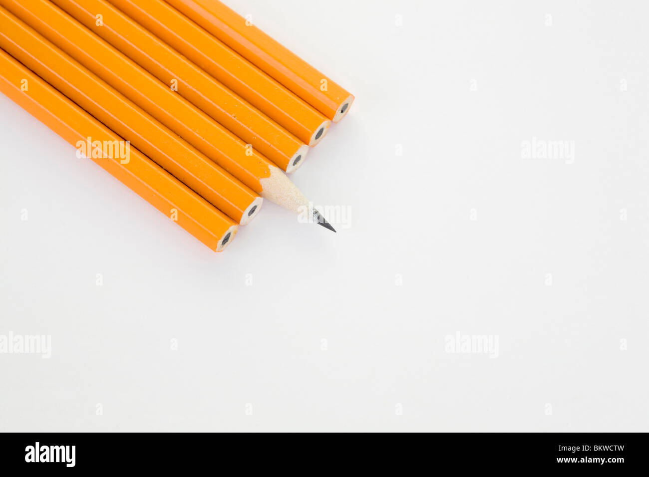 Ein spitzer Bleistift sitzt neben unsharpened Einsen. Stockfoto