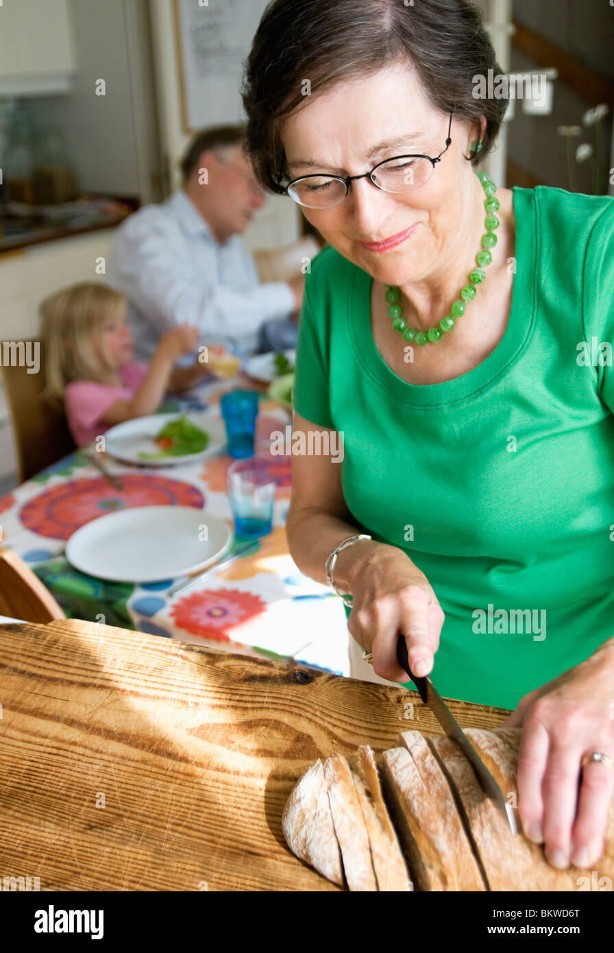 Großmutter Brot schneiden Stockfoto