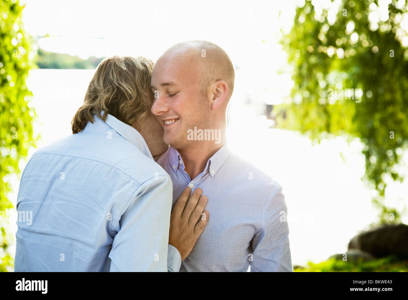 Zwei glückliche Schwule durch Wasser stehen Stockfoto