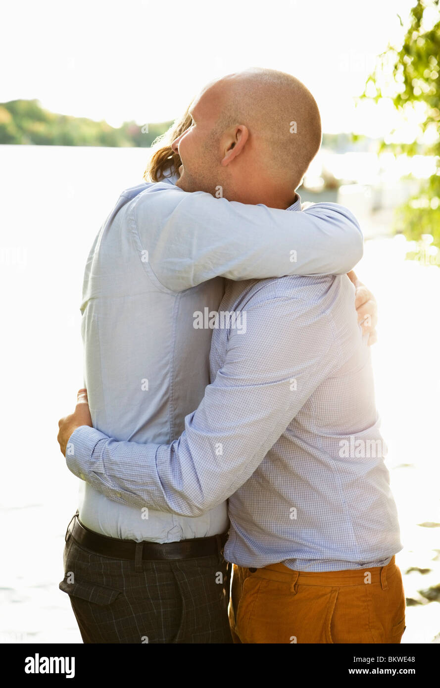 Zwei schwule Männer umarmen durch die Wasser Rand Stockfoto