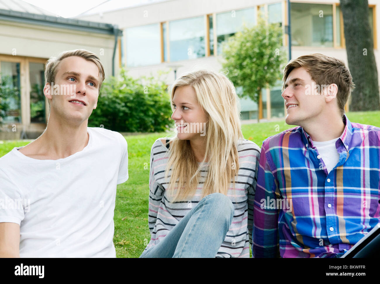 Drei Studenten sitzen auf dem Rasen Stockfoto