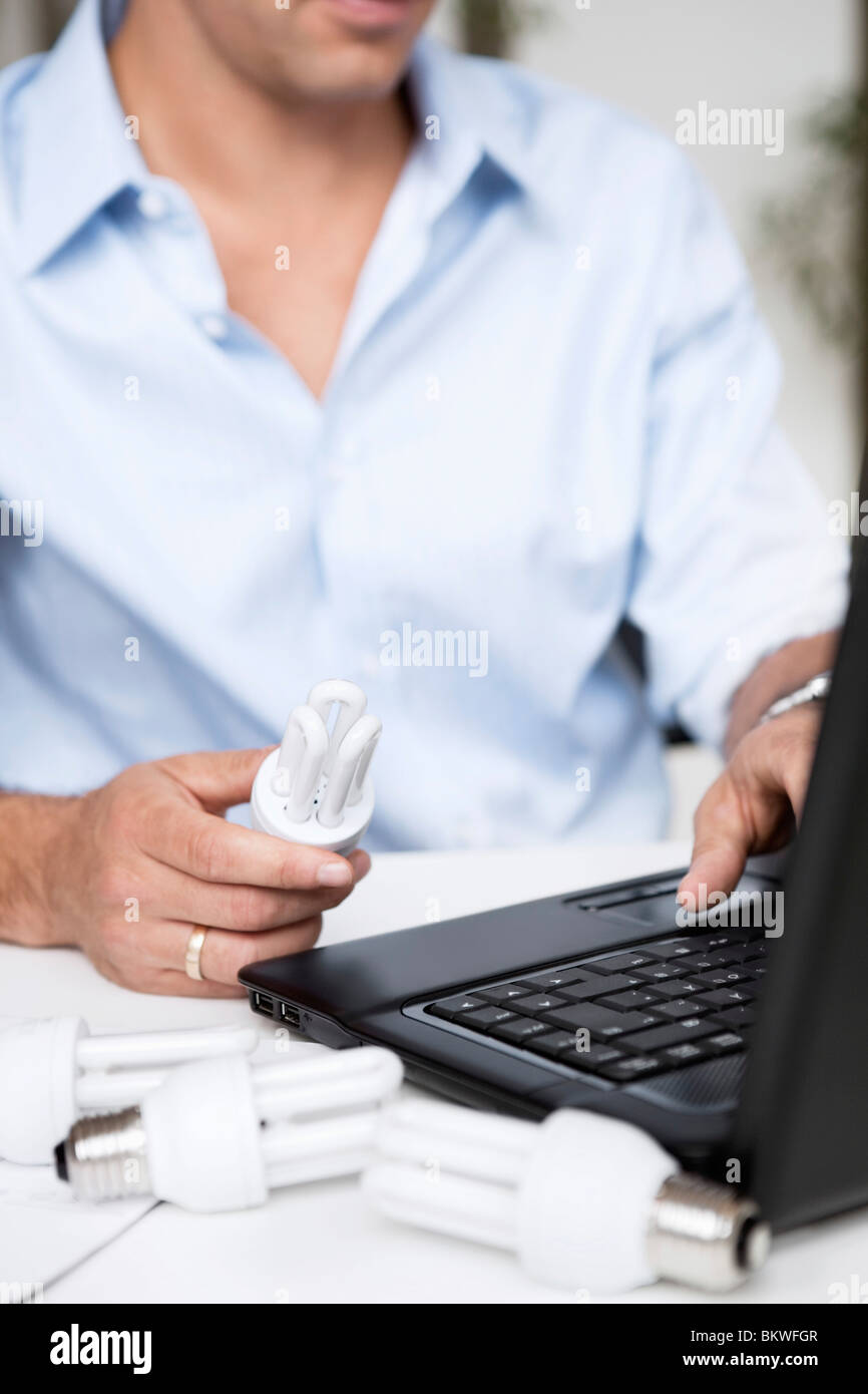 Mann mit Laptop und Glühbirnen Stockfoto