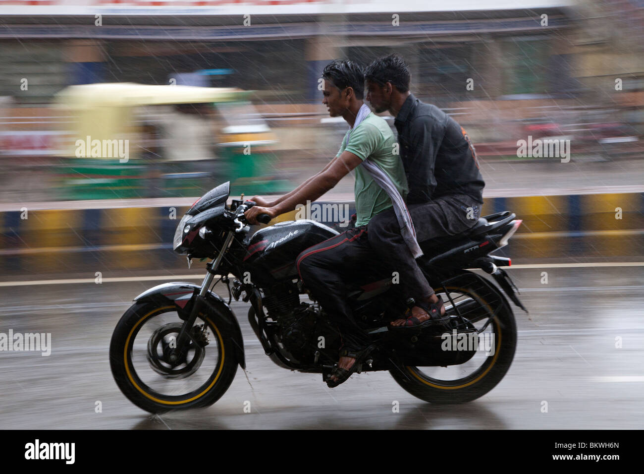 Indien, Uttar Pradesh, Agra, Motorradfahrer und Beifahrer im schweren Monsun-Regen Stockfoto