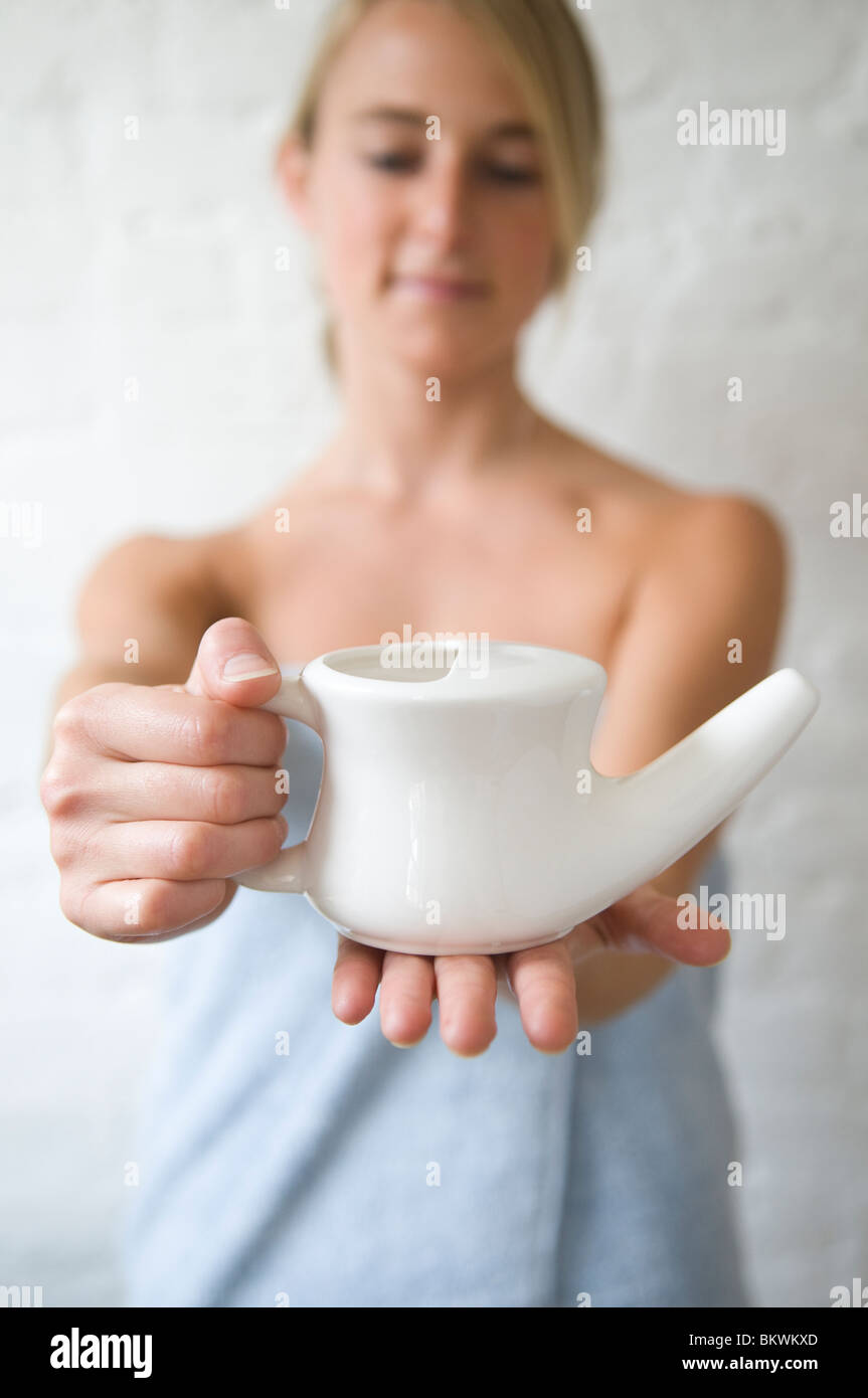 Frau hält einen Neti pot Stockfoto