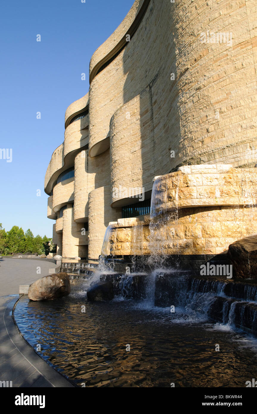 National Museum of the American Indian Exterior Washington DC // WASHINGTON DC – Außenansicht des National Museum of the American Indian der Smithsonian Institution. Das Gebäude verfügt über eine markante geschwungene, mit Steinen verkleidete Fassade und ein markantes Wasserspiel im Vordergrund. Stockfoto