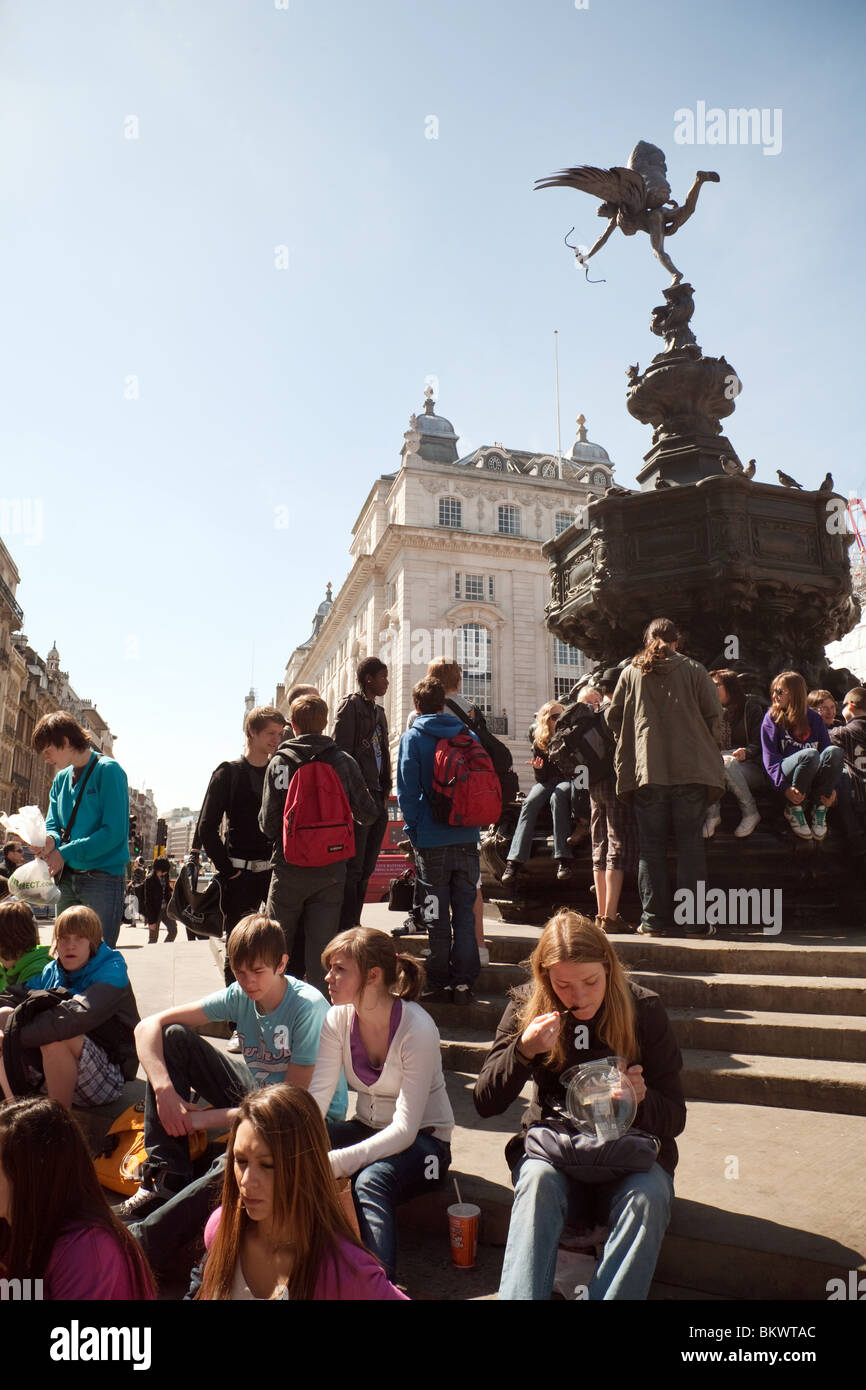 Teenager Jugendliche Touristen rund um die Statue des Eros, Piccadilly Circus, London UK Stockfoto