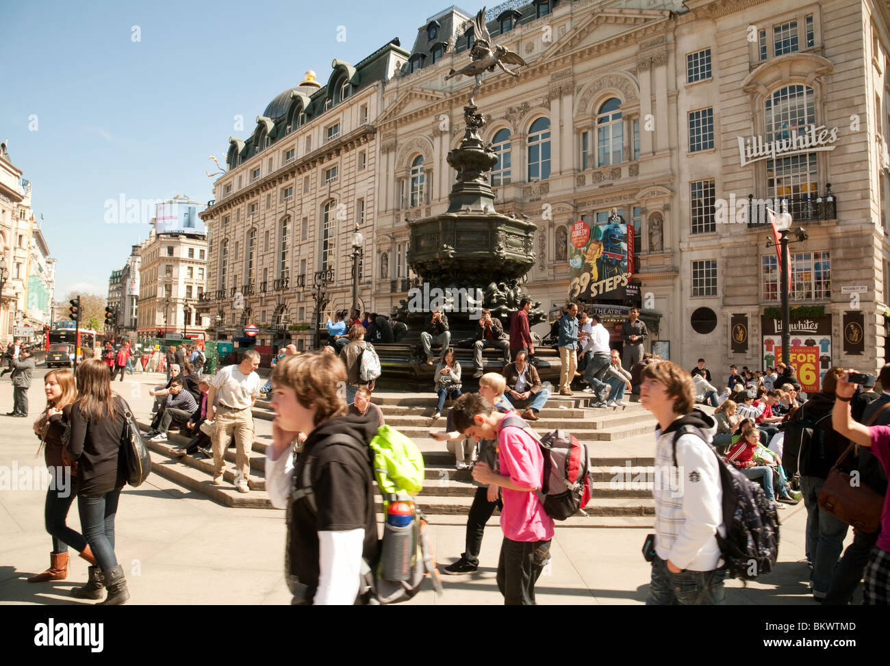 Teenager Jugendliche Touristen rund um die Statue des Eros, Piccadilly Circus, London UK Stockfoto