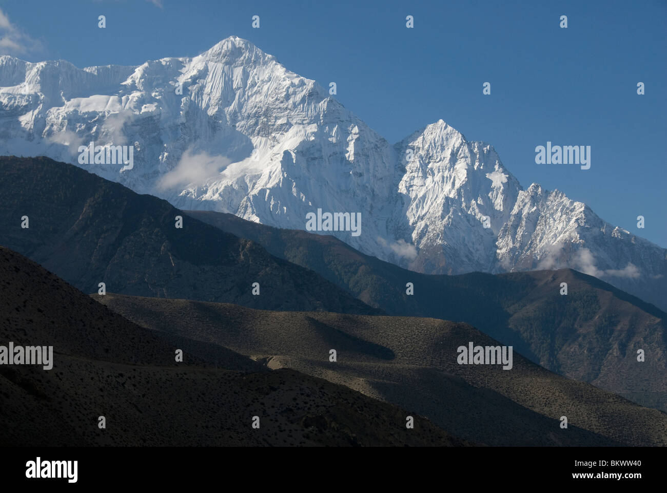 Schneebedeckte Berg über einsamen Hügeln, Mustang District, Nepal, Annapurna Circuit, Kagbeni, Nilgiri North, Stockfoto