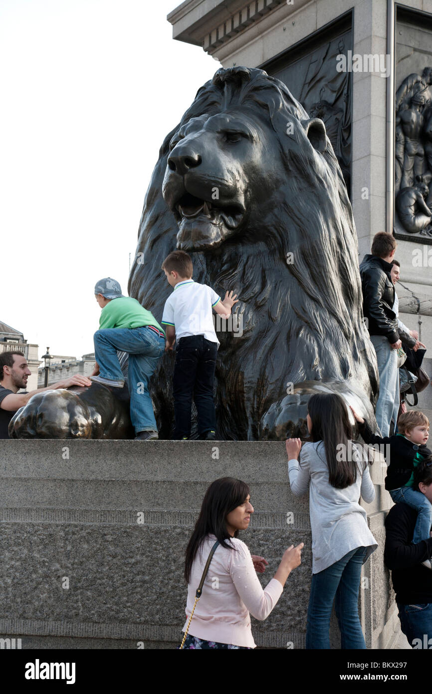 Kinder klettern Löwe Statue Trafalgar Square, London Stockfoto