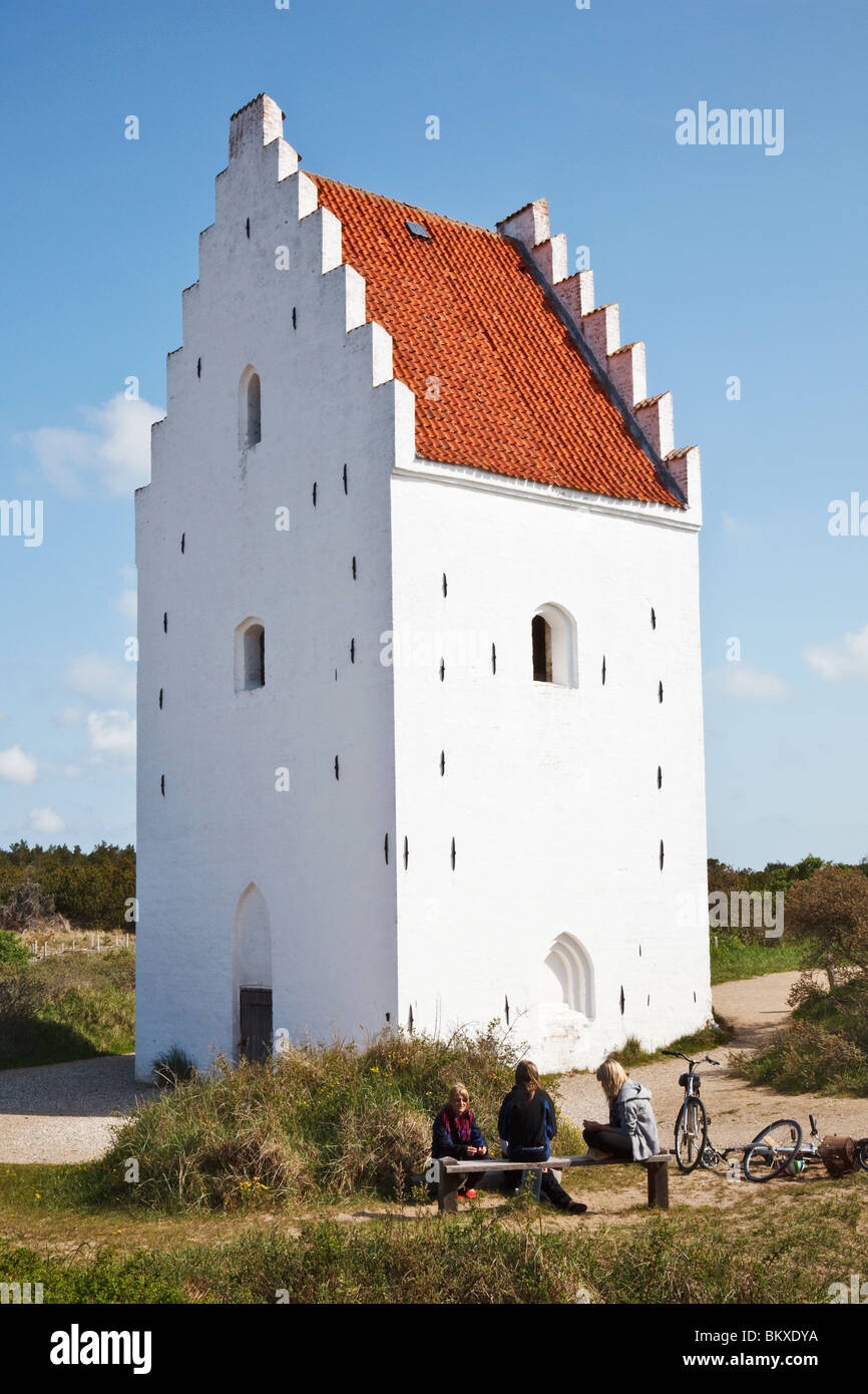 Der Sand verschlungen Buried Kirche von Skagen. Dänemark. Mit drei jungen Mädchen auf einer Bank Stockfoto