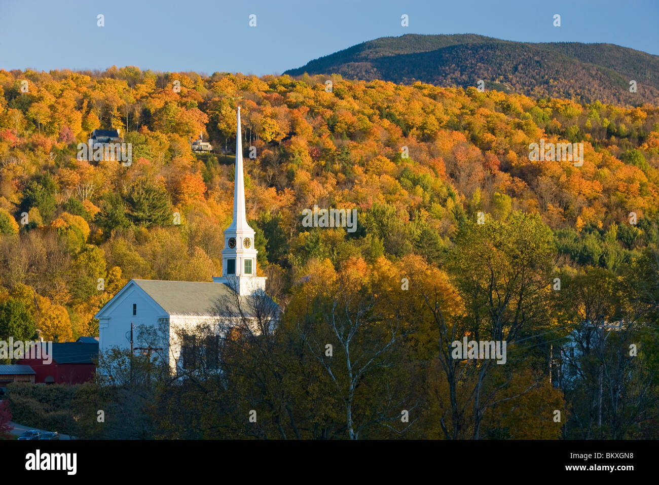 Der Mond, eine Kirche und Herbstlaub in Stowe, Vermont. Stockfoto