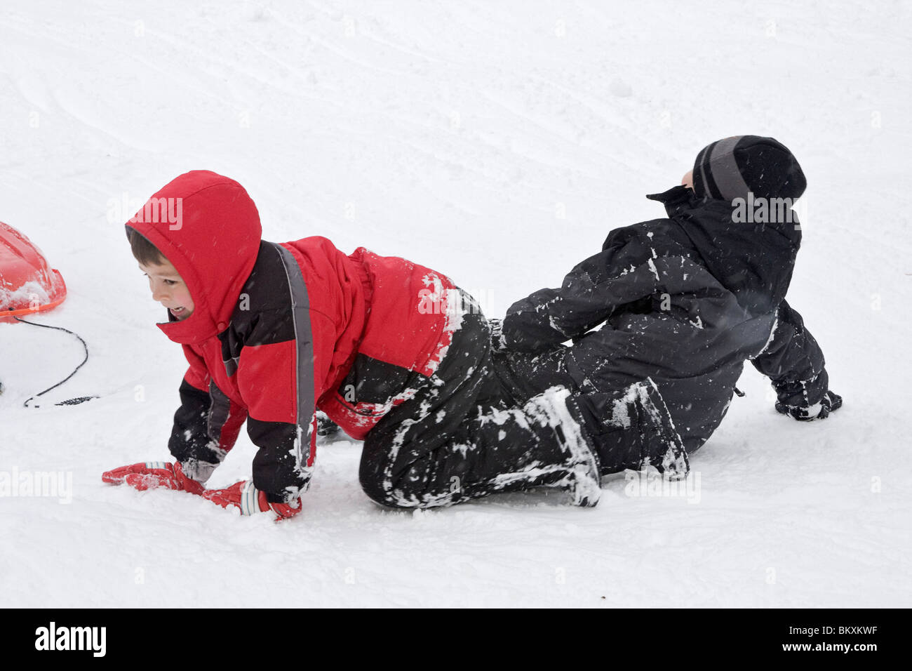 Kinder-Schlitten auf kurze Piste im Winter, South Lake Tahoe, Kalifornien, USA. Hier holen Jungs sich nach einem Absturz. Stockfoto
