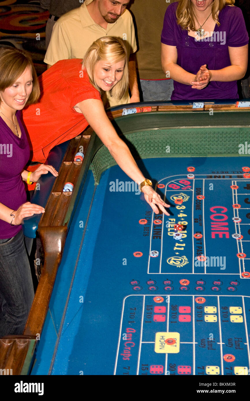 Szene auf Gaming-Etage des Casino - erregte Frau wirft Würfel am Craps-Tisch. South Lake Tahoe, Nevada, USA. Stockfoto