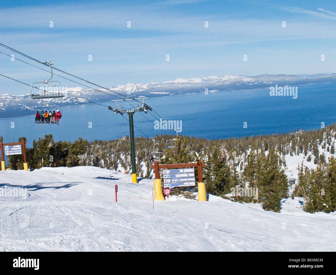 Skifahrer am Skilift von halbem Weg bis die Heavenly Mountain Resort Ski-Pisten im Winter. Lake Tahoe ist im Hintergrund. Stockfoto