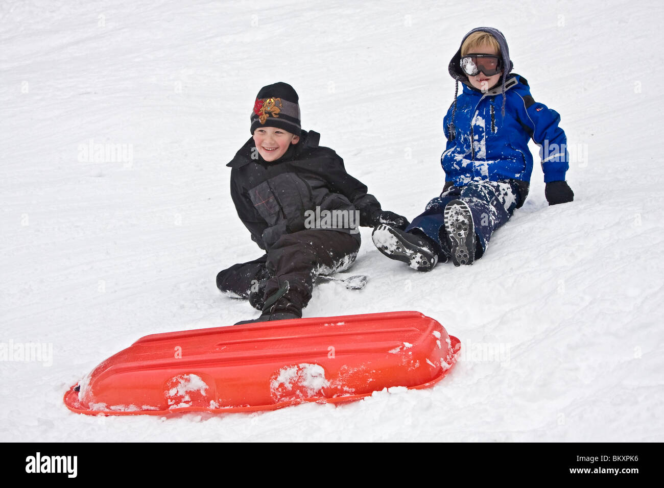 Kinder-Schlitten auf kurze Piste im Winter, South Lake Tahoe, Kalifornien, USA. Hier entwirren zwei jungen sich nach einem Absturz. Stockfoto