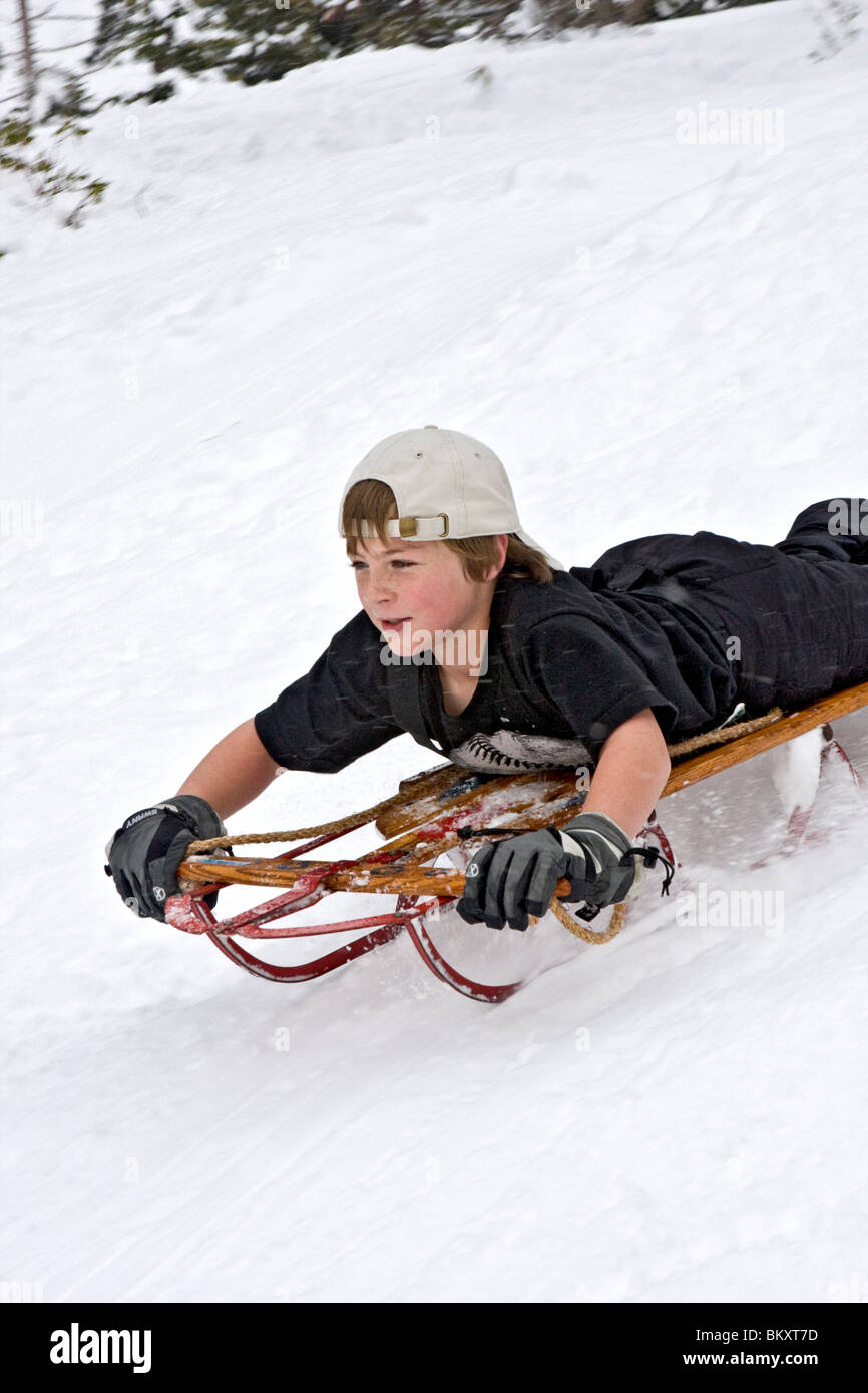 Kinder-Schlitten auf kurze Piste im Winter, South Lake Tahoe. Hier kommt ein Junge bergab mit einem entschlossenen Blick auf seinem Gesicht Stockfoto