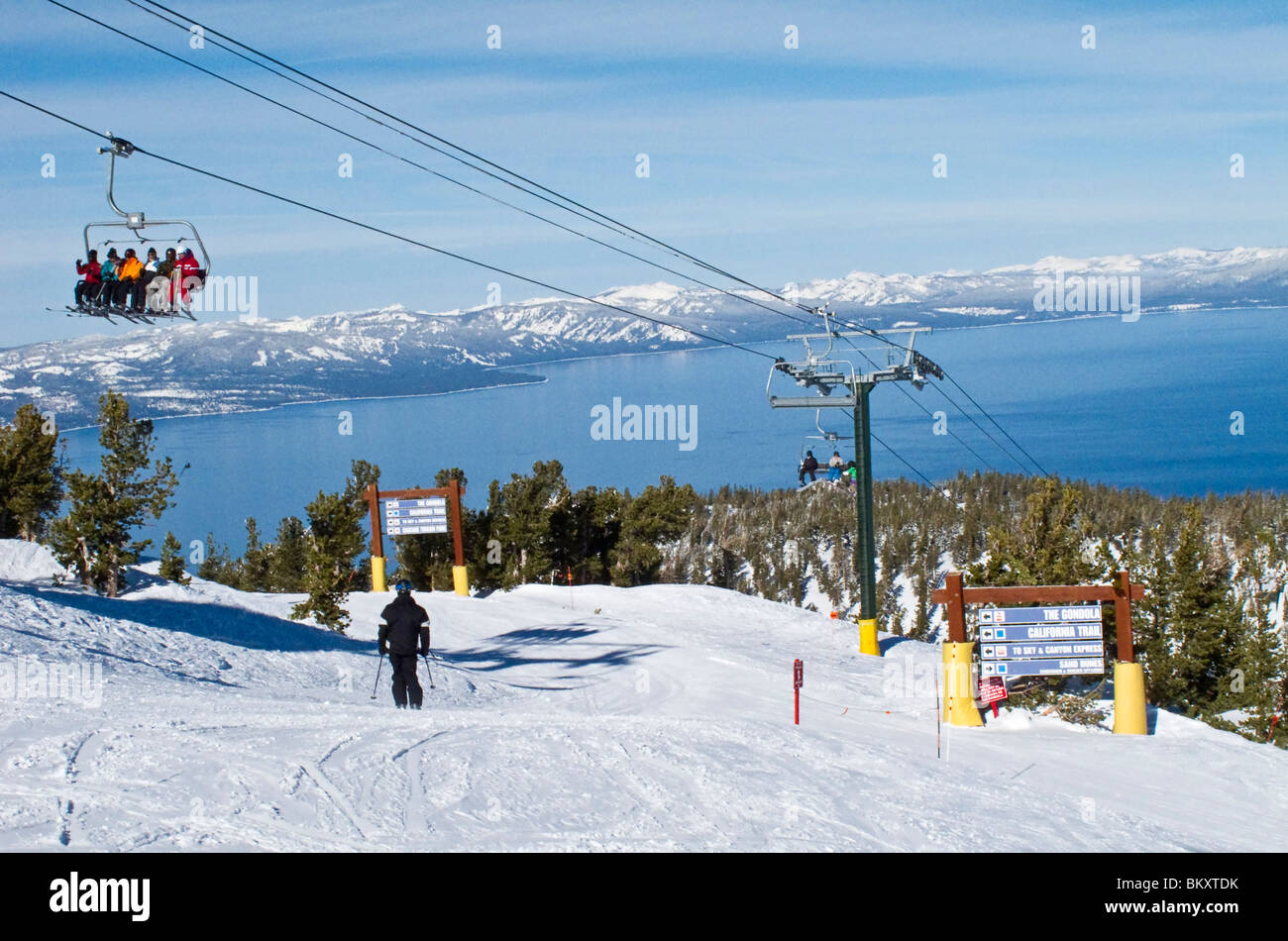 Skifahrer am Skilift von halbem Weg bis die Heavenly Mountain Resort Ski-Pisten im Winter. Lake Tahoe ist im Hintergrund. Stockfoto