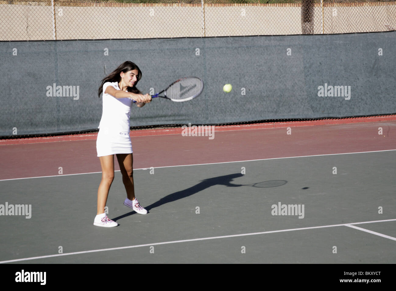Mädchen spielen Tennis Hits Ball zurück Stockfoto