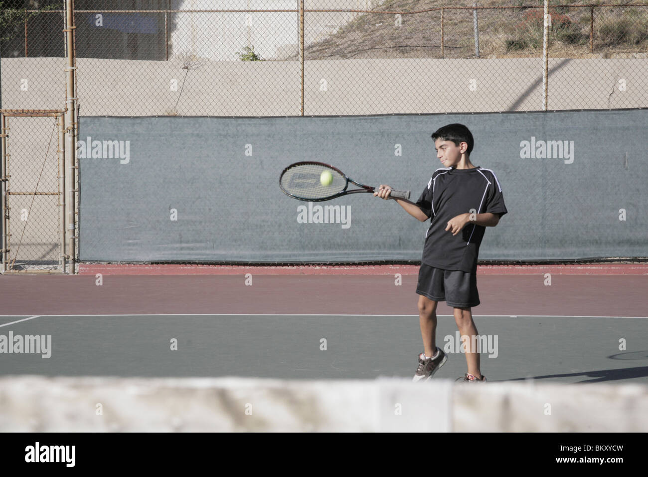 Jungen spielen Tennis Treffer zurück Stockfoto