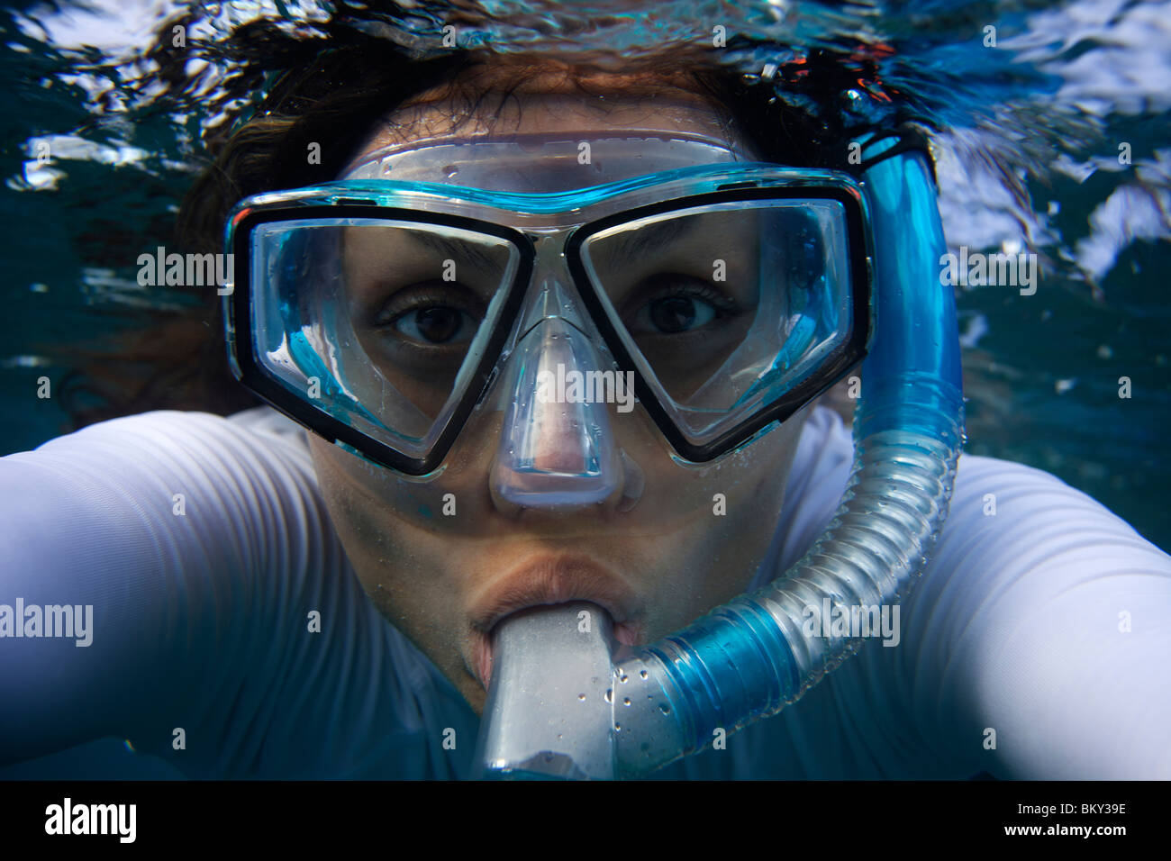 Junge Frau schaut direkt in die Kamera durch eine Maske beim Schnorcheln in Maui, Hawaii. Stockfoto