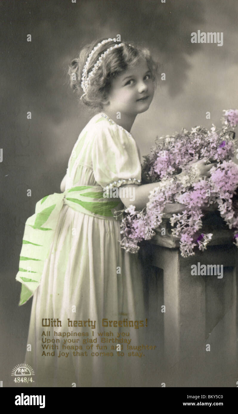 Grußkarte (c.1912).  Junges Mädchen mit einem Bouquet von lila Blüten Stockfoto