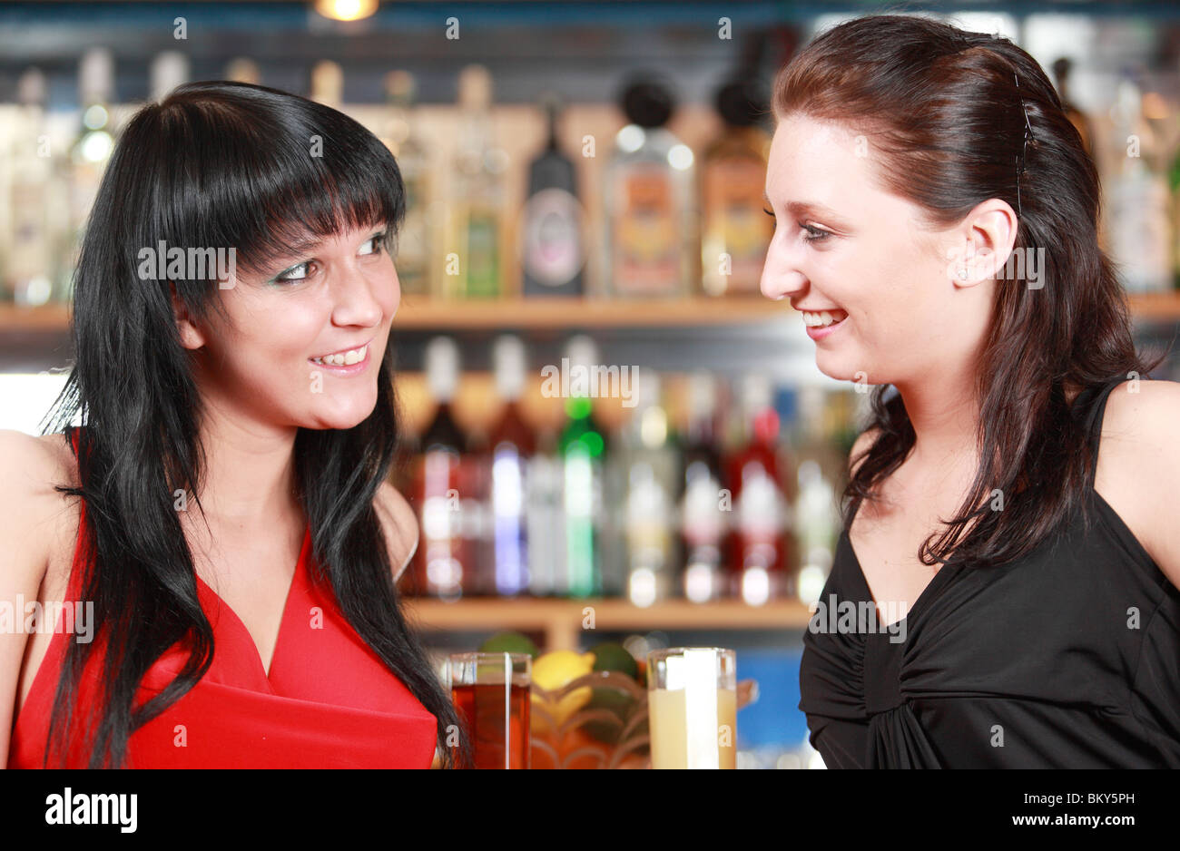 Porträt der beiden jungen Frauen sitzen an der Bar mit Getränken Stockfoto