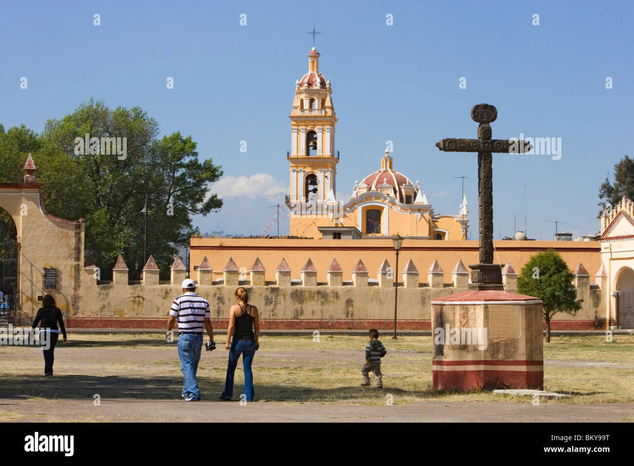 Familie zu Fuß über das Gelände des Ex-Convento de San Gabriel in Cholula, die Kirche von San Pedro ist im Hintergrund, Bundesstaat Stockfoto