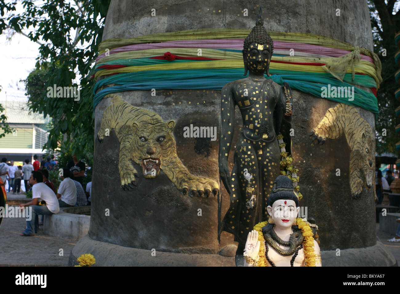 Statue von Shiva und Buddha vor einer Glocke am Wat Bang Phra, ein buddhistischer Tempel in Thailand, wo Mönche Anhänger tattoo. Stockfoto