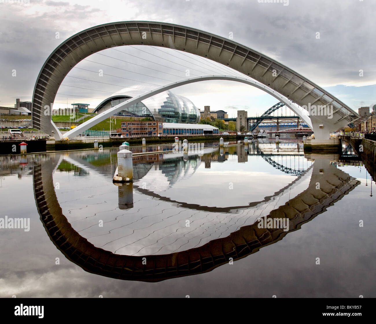 Millennium Bridge am Fluss Tyne Gateshead Winking blinken Augenhöhe mit Spiegelbild im Fluss Tyne Salbei im Hintergrund dem Erdboden gleichgemacht Stockfoto