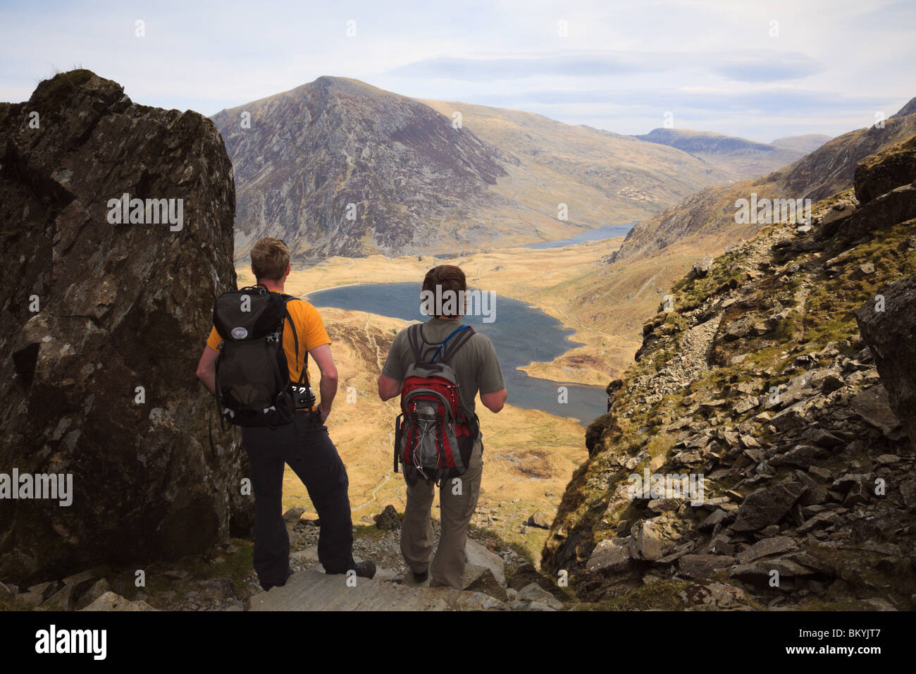 Zwei Wanderer auf Llyn Idwal aus der Küche des Teufels in den Bergen von Snowdonia National Park (Eryri). Cwm Idwal North Wales UK Großbritannien Stockfoto