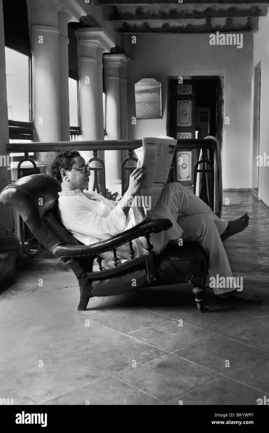 Mann liest eine Zeitung auf dem Balkon Stockfoto