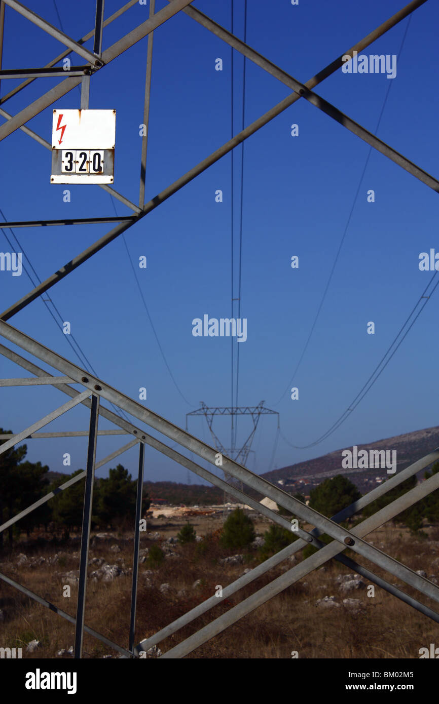 Ein Detail der Übertragung Linie Pylon mit einem Warnhinweis. Stockfoto