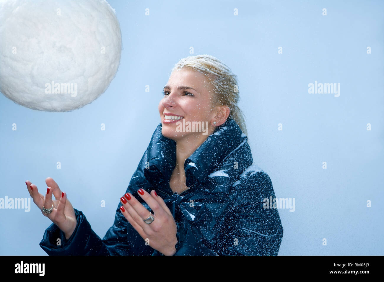 Junge Frau wirft große Schneeball Stockfoto