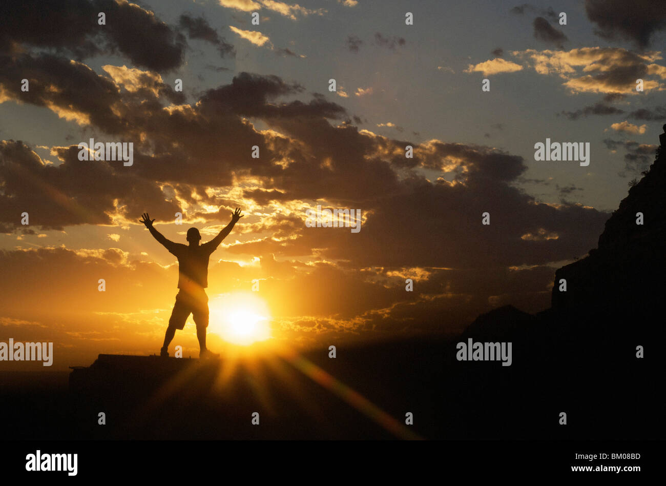 die Natur Landschaft und inspirierende Konzepte: Silhouette des Menschen feiern die dramatischen Sonnenuntergang Himmel stehend Arme weit gespreizt Stockfoto