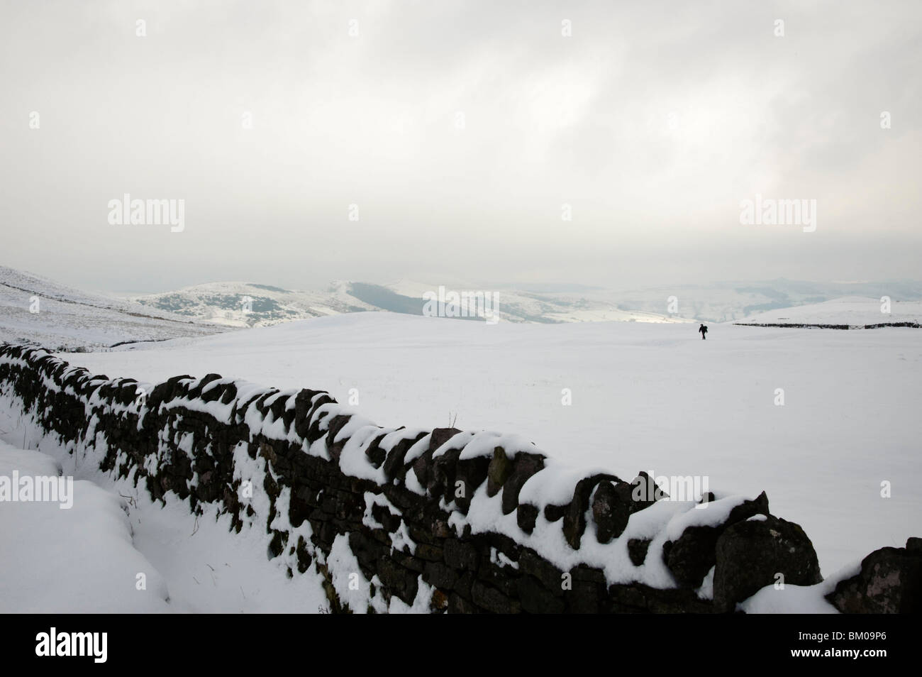 Winter, einsame Figur im Schnee bedeckt Landschaft, Derbyshire, Peak District, England, UK Stockfoto