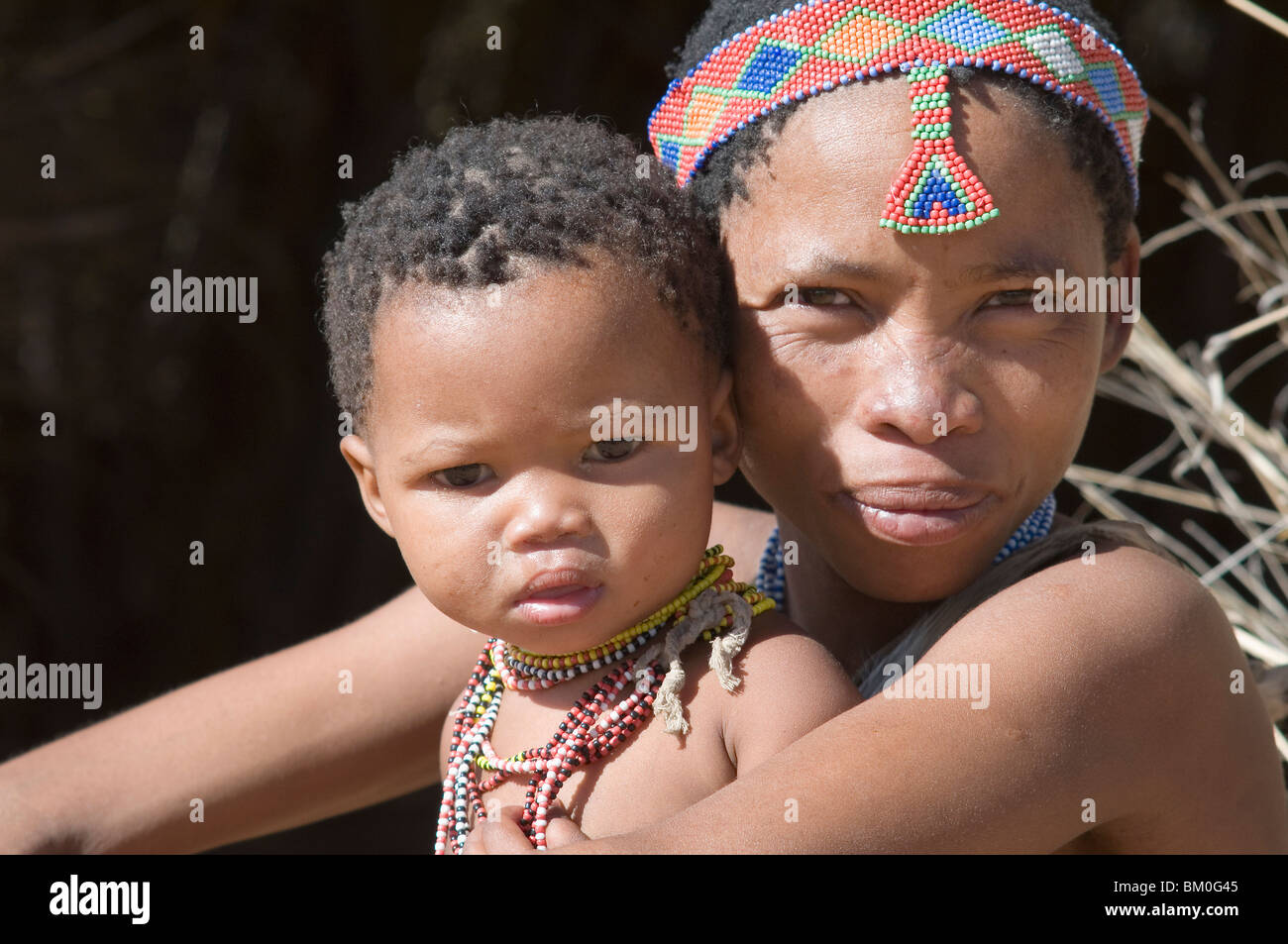 Sani-Mutter und Kind (12-17 Monate) mit handgefertigten Perlen Kopf ornament, Grashoek, Provinz Buschmannland, Namibia Stockfoto
