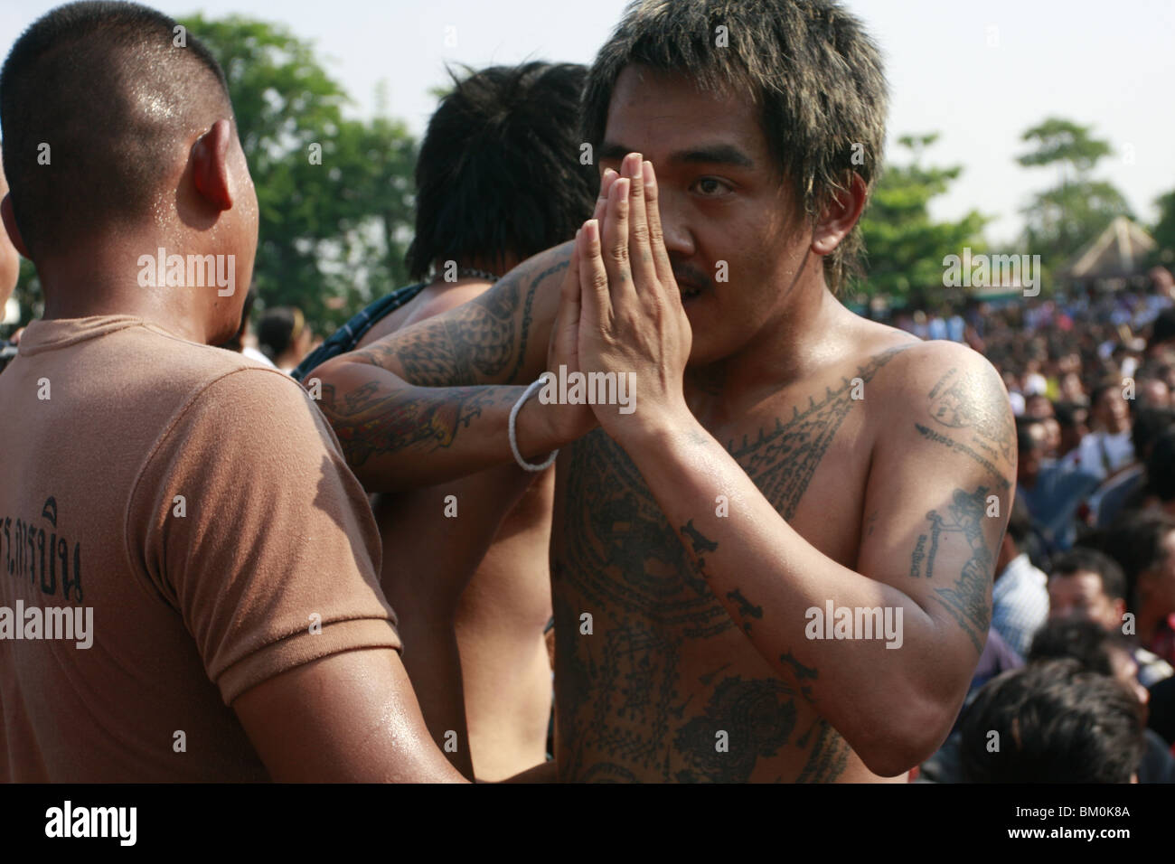 Ein Mann im Gebet Wai Kru tagsüber am Wat Bang Phra, ein buddhistischer Tempel in Thailand, wo Mönche Anhänger tattoo. Stockfoto