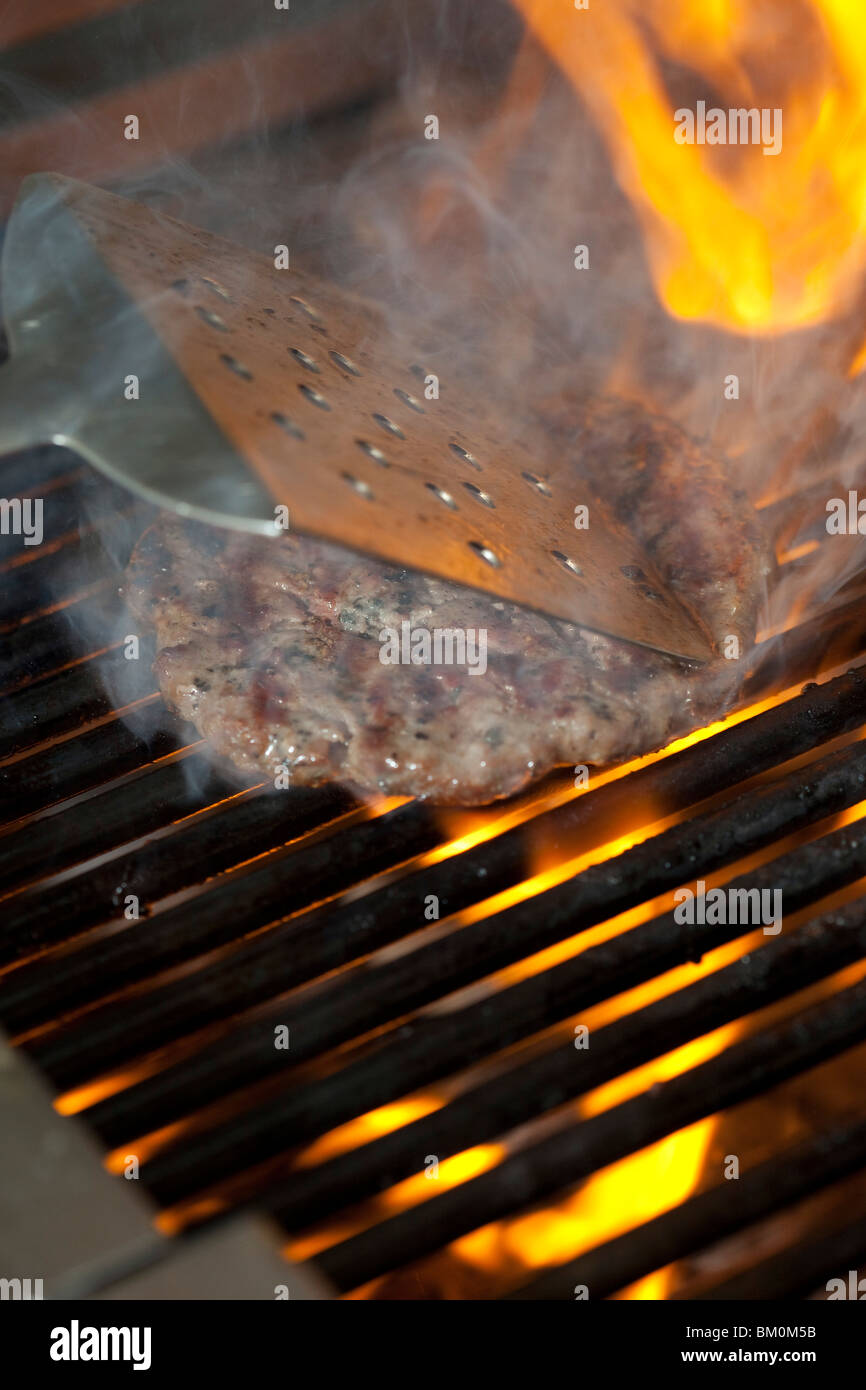 Einen geflammte Beef-Burger auf dem Grill Kochen Stockfoto