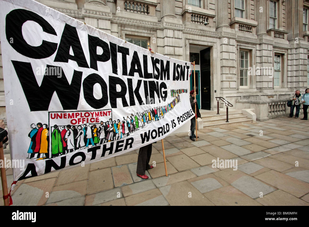 Eine antikapitalistische Demo mit einem großen Banner im Zentrum von London Stockfoto
