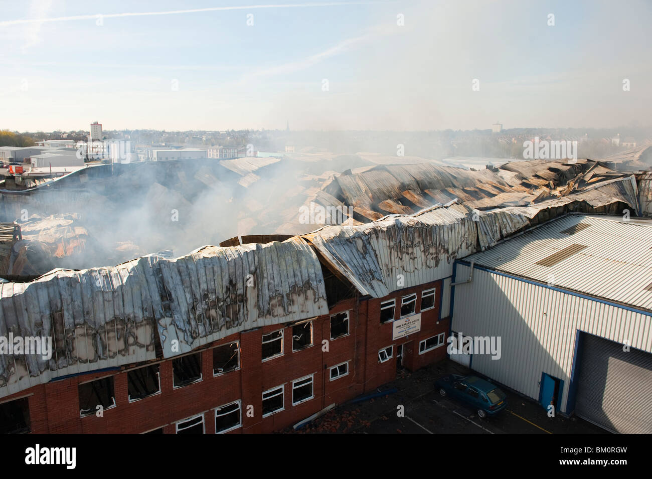 Große Fabrik und Lager zusammengebrochen und schwelende nach großen Vorabend - Feuer Feuerwehr Dämpfung nach unten Stockfoto