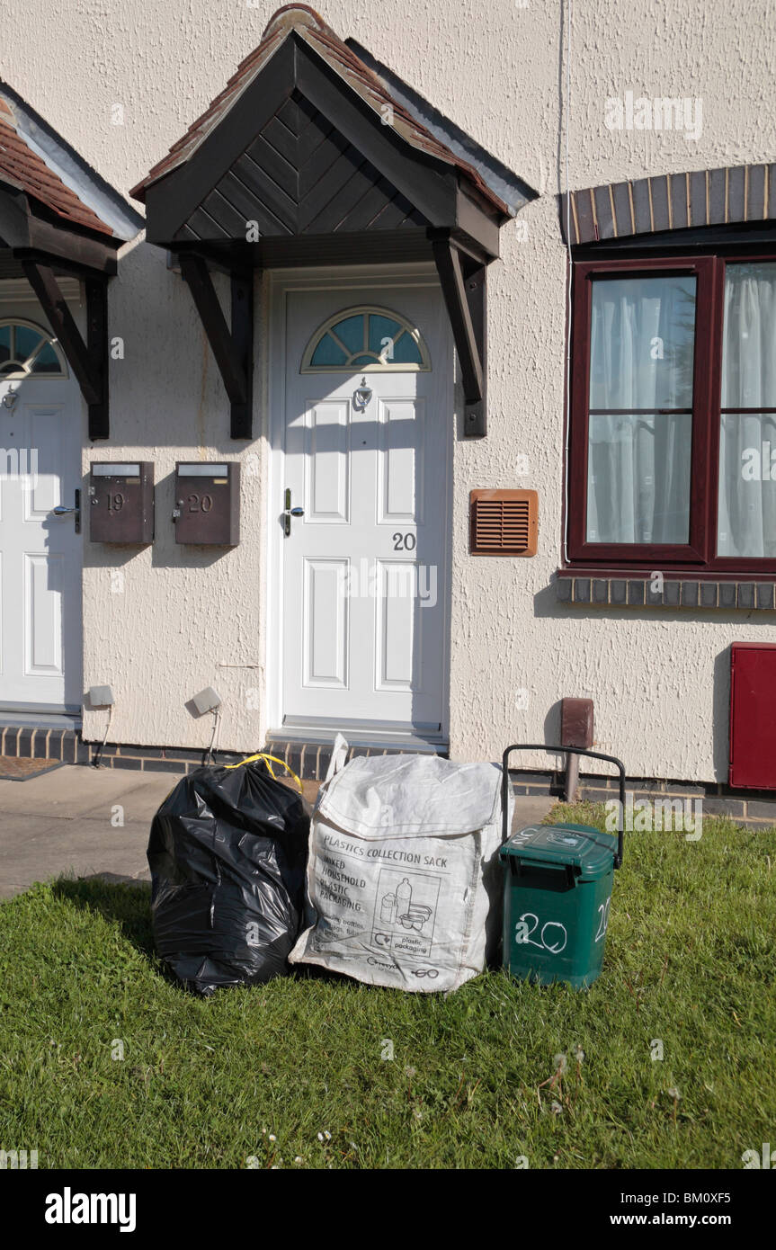 Normalen schwarzen Auffangbeutel, Kunststoff-Sammelbehälter und Essen Abfallbehälter außerhalb Residenz in Hounslow Middx, UK. Stockfoto