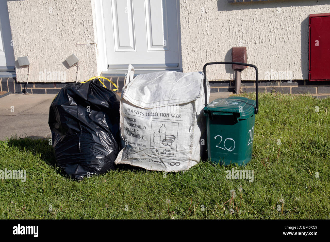 Normalen schwarzen Auffangbeutel, Kunststoff-Sammelbehälter und Essen Abfallbehälter außerhalb Residenz in Hounslow Middx, UK. Stockfoto